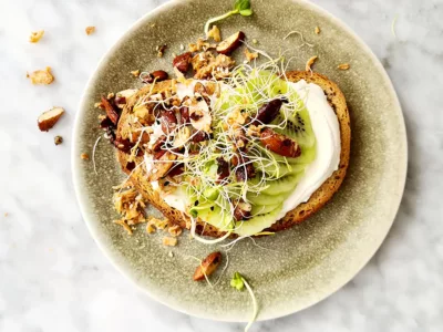 Kiwi op brood met noten Broodje kiwi met vegan spread en krokante noten